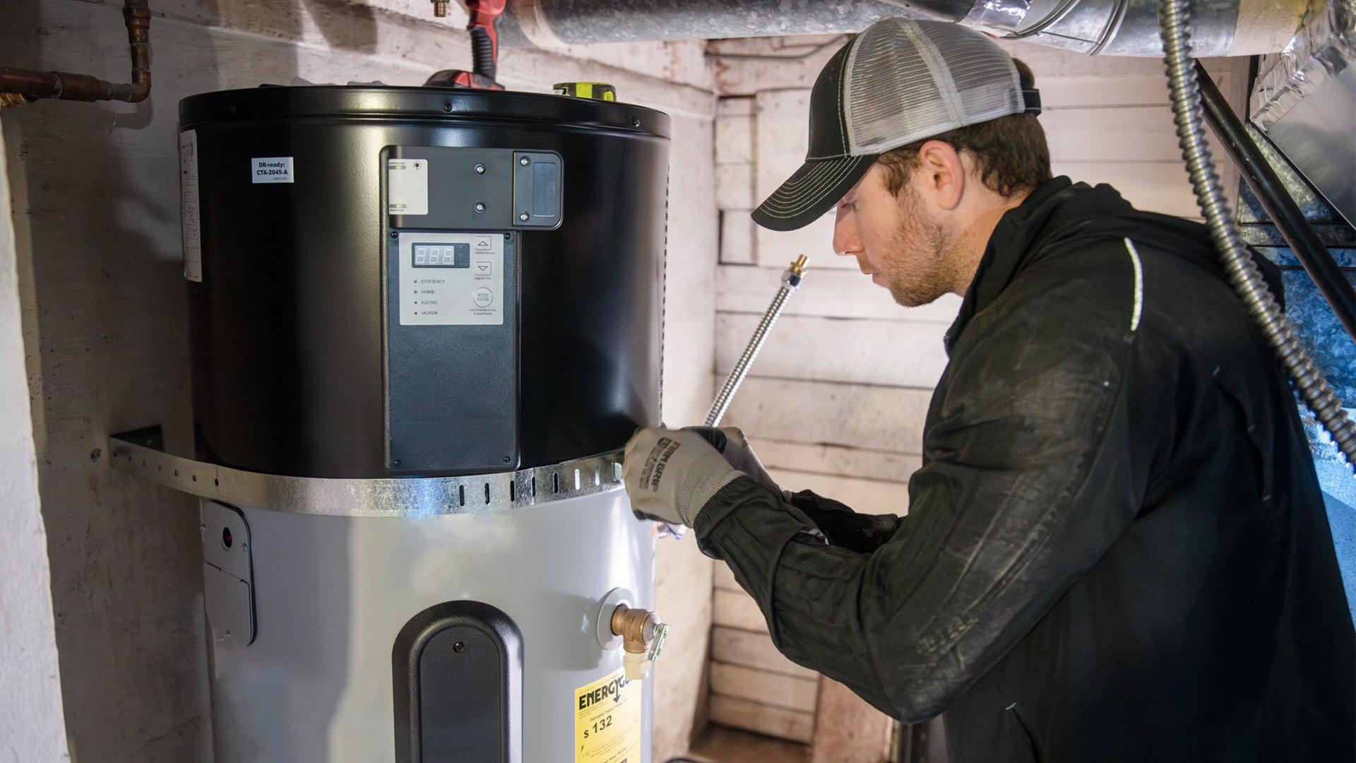A professional plumber installs an ENERGY STAR water heater in a basement in this photo courtesy of Hot Water Solutions.